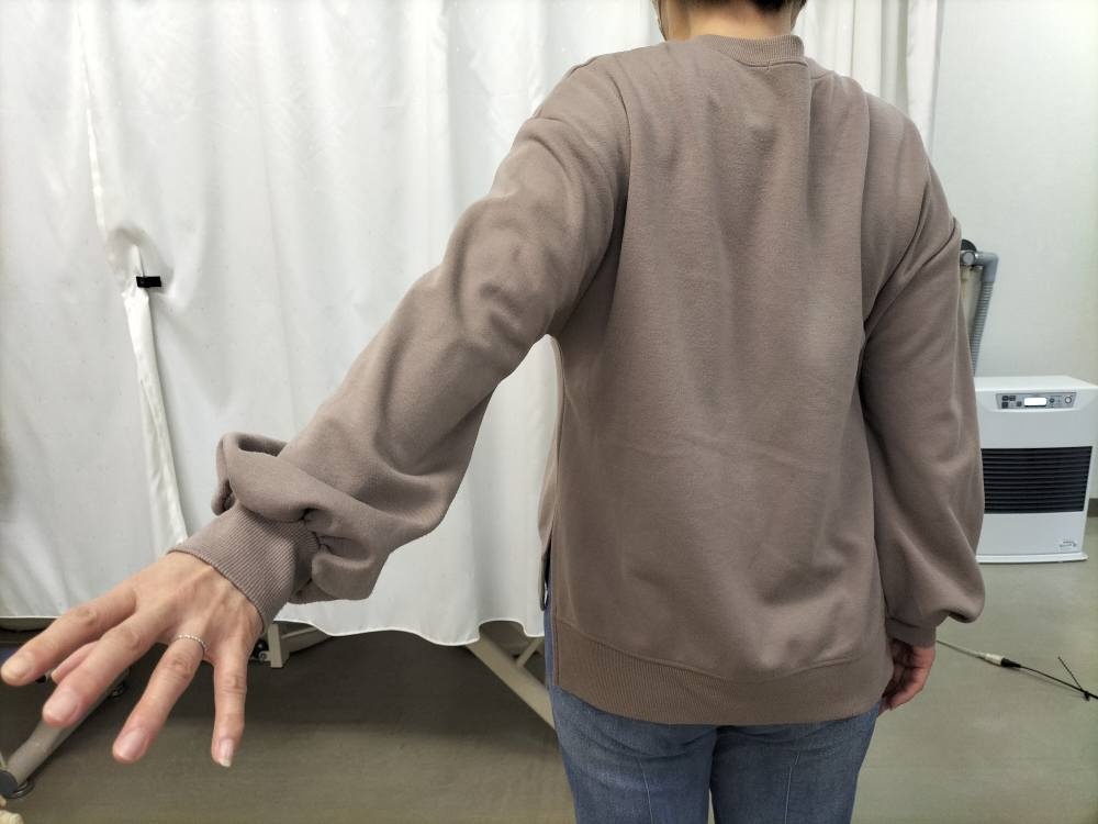 手を後ろに伸ばす動作