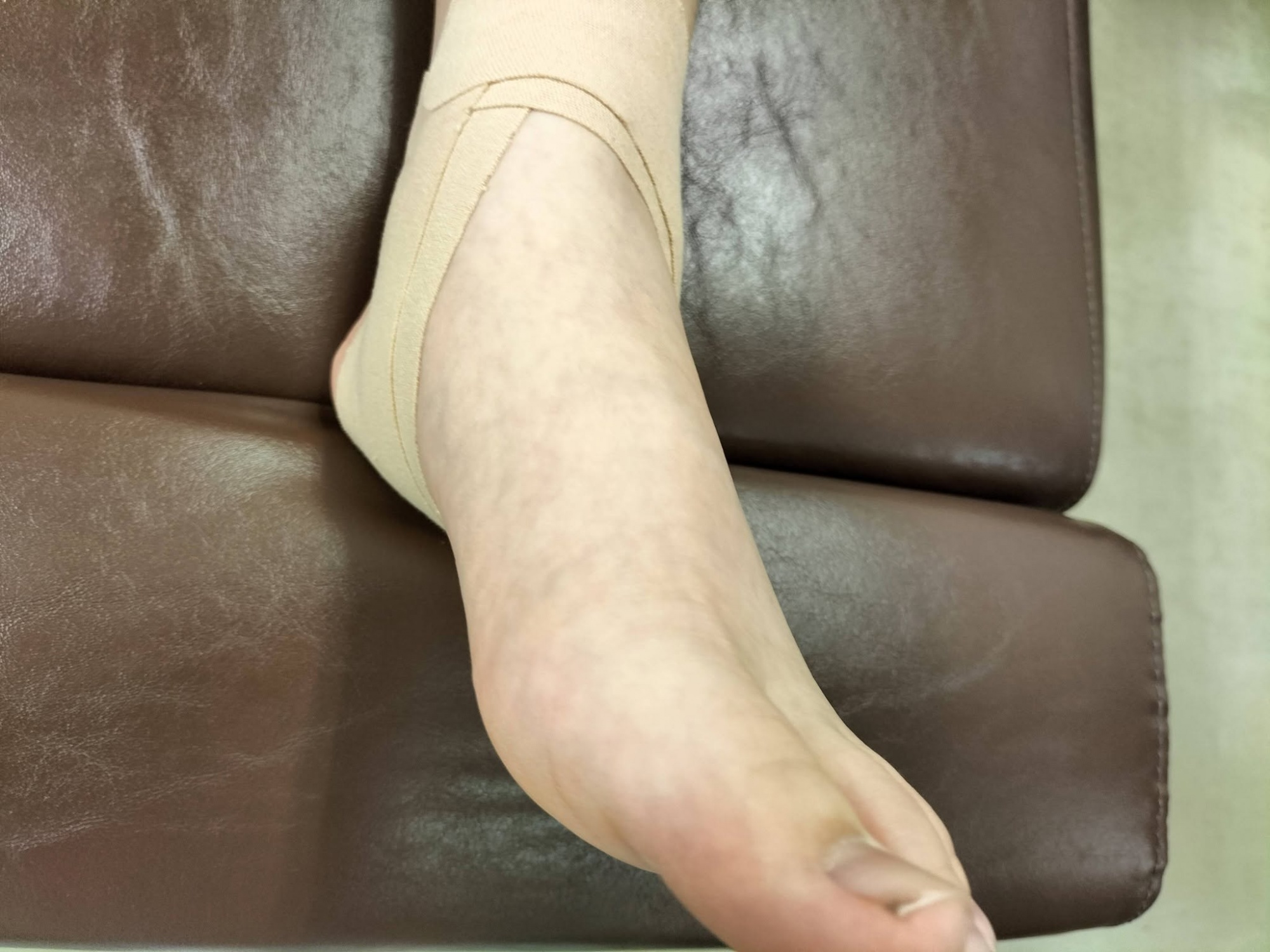 小学生の足首捻挫に対して、関節をサポートし踏み込みの衝撃を和らげるために施されたスポーツテーピングの様子